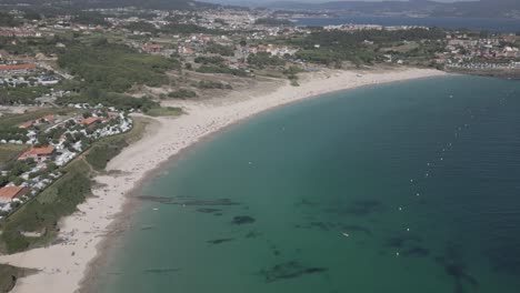 Raw-Aerial-Footage-of-Beach-in-Coastal-Village-with-Emerald-Clear-Water