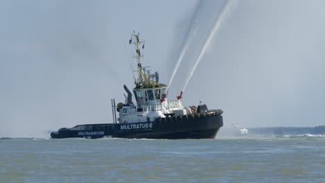 Tugboat-Multratug-6,-fire-boat,-spins-on-axis-with-water-cannon-at-full-blast