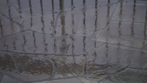 Slow-Motion-Shot-Of-Rain-Drops-Falling-Over-Stone-Tiles