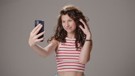 Attraktive-Junge-Kaukasische-Frau-Macht-Ein-Paar-Posen-Für-Selfies,-Frontalansicht