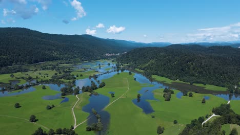 Beautiful-aerial-panoramic-of-Cerknica-Intermittent-Lake-in-valley-and-mountain-surroundings