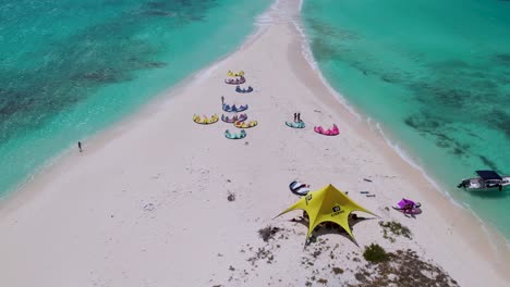 Aerial-reveal-of-kite-surfers,-their-base-location-and-Isthmus-Cayo-De-Agua-Los-Roques