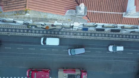 In-the-early-morning-hours-before-the-World-Youth-Days,-an-aerial-view-captures-the-charm-of-Lisbon's-typical-streets,-adorned-with-passing-cars-and-the-promise-of-a-vibrant-day-ahead