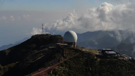 Pico-Arieiro,-Madeira:-aerial-view-in-a-circle-and-at-a-short-distance-from-the-radar-station-and-with-the-background-of-mountains-and-clouds