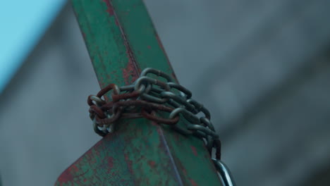Iron-rusty-chain-wrapped-around-a-green-post