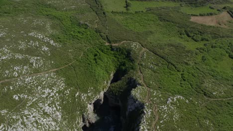 Hiking-trail-across-cavern-and-stunning-green-bufones-de-pria-asturias-spain-blowholes,-aerial