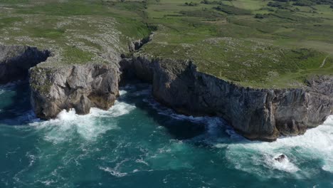 Bufones-de-pria-asturias-spain-sea-cliffs-on-sunny-day,-slow-motion-bird's-eye-view-pullback