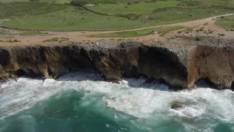 Aerial-trucking-pan-along-green-beachside-cliffs-bufones-de-pria-asturias-spain,-sunny-day