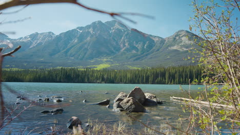 Beautiful-Pyramid-Lake-and-Mountain-Nature-in-Jasper-National-Park---Blurred-Branches-Foreground,-Slider-Reveal