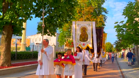 Priest-with-cross-and-followers-with-banners-walk-on-street-during-Orthodox-mass