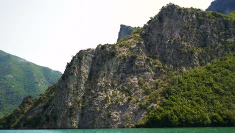 Albania,-Lake-Koman,-view-of-the-slopes-of-beautiful-mountains-amidst-emerald-waters