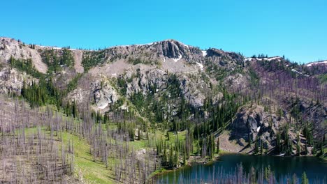 Drone-aerial-shot-pushing-in-over-a-backcountry-backpacking-lake-past-a-rocky-mountain-range