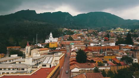 Aerial-view-of-one-of-the-streets-of-Santa-Fé-in-Bogotá,-Colombia,-with-colonial-houses-and-mount-Monserrate-in-the-background