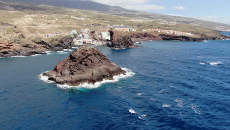Roques-de-Fasnia,-Tenerife:-aerial-view-in-orbit-of-the-rock-formations-of-Fasnia,-where-you-can-see-the-nearby-beach-and-the-intense-blue-sea