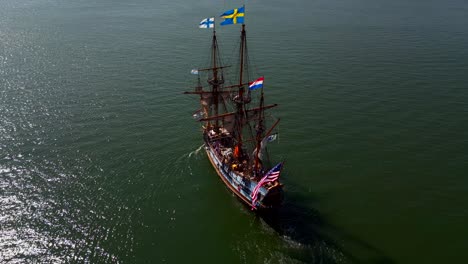 An-aerial-view-of-a-17th-century-wooden-ship-sailing-out-on-Greenport-Harbor-on-Long-Island-on-a-sunny-day