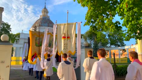Religiöse-Anhänger-Gehen-In-Der-Sonne-Mit-Bannern-In-Einer-Prozession-Zur-Orthodoxen-Kirche