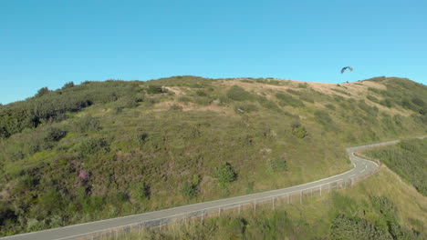 El-Parapente-Se-Desliza-Sobre-La-Colina,-La-Carretera-De-Montaña,-El-Desvanecimiento.