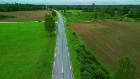 Aerial-View-Of-A-Two-Lane-Highway-In-Rural-Landscape-With-Agricultural-Land