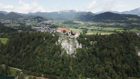 Burg-Auf-Einem-Hügel-Neben-Einem-See-Mit-Bergen-Im-Hintergrund
