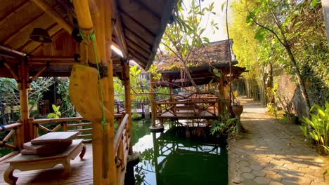 Sliding-shot-of-bamboo-hut-on-the-pond