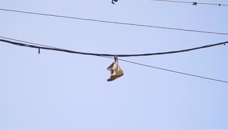 Shoes-hanging-by-laces-from-a-wire