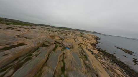 Drone-flight-passing-low-over-rocky-surface-of-Ramsvik-coastline-in-Sweden