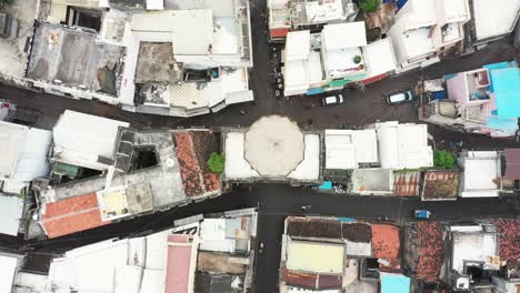 Aerial-drone-camera-panning-from-above-shows-a-clock-tower-in-the-middle-of-narrow-streets