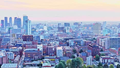 Zoomed-drone-lifting-shot-of-the-illuminated-skyline-of-Manchester-after-sunset