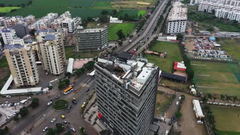 Aerial-rotate-shot,-rear-drone-camera-rotating-around-a-commercial-building-in-the-middle-of-Rajkot-city