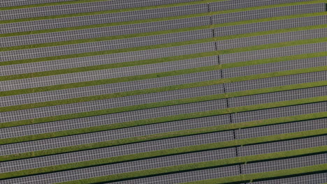 Lufteinschub-Mit-Rotation-Auf-Einem-Riesigen-Solarkraftwerk-Mit-Mehreren-Solarpaneelen-Auf-Einem-Grünen-Hügel-In-Deutschland,-Erneuerbare-Energie,-Luftaufnahmen