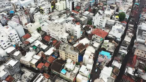 Aerial-drone-camera-circling-the-cobbled-streets-of-old-houses-and-high-rise-buildings