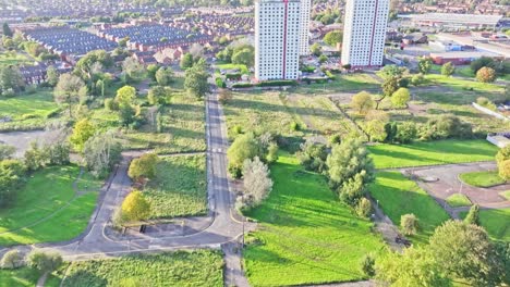 Aerial-drone-shot-of-an-area-of-Manchester-with-a-public-park-flying-in-the-direction-of-a-residential-area-with-home-and-apartment-blocks