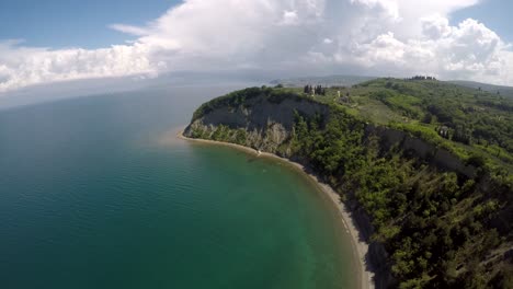 Drone-shot-of-a-cliff-moving-away-and-tilting-down