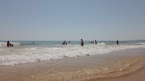 Bañistas-En-La-Orilla,-Playa-De-Falèsia,-Algarve