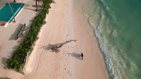 Aerial-shot-of-a-motorbike-riding-on-a-pristine-beach