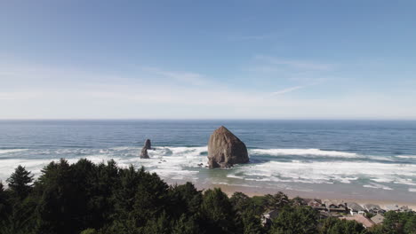 Hills-of-pine-trees-give-way-to-Haystack-Rock-at-Cannon-Beach