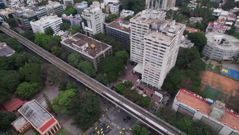 Aerial-perspective-of-a-rooftop-terrace-and-metro-train-track-seen-from-above-an-office-building