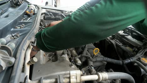 Mechanic-tightening-screws-and-bolts-expertly-assembles-cylinder-headcover-of-a-car-engine