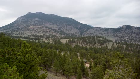 Aerial-view-of-mountain-terrain-over-trees,-Estes-Park,-Eagle-Cliff-Mountain,-Colorado
