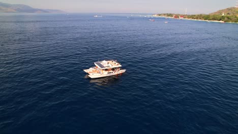 Una-Joven-Viajera-En-Un-Moderno-Catamarán-Con-Paneles-Solares-Navegando-En-El-Mar-Azul-Alrededor-De-Las-Islas-Gili-En-Indonesia.