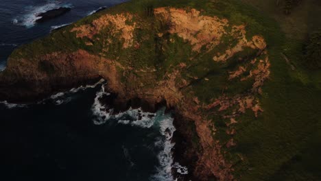 Luftparallaxenaufnahme-Der-Wunderschönen-Küste-Der-Insel-Norfolk,-Australien,-Mit-Blick-Auf-Die-Majestätischen-Klippen-Mit-Vegetation-Und-Das-Tiefblaue-Meer,-Während-Wellen-Vom-Ufer-Abprallen