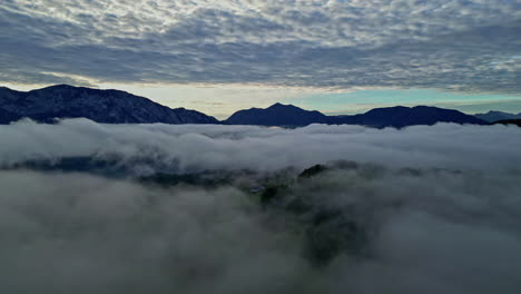 Mountain-peeks-above-cloudscape,-aerial-drone-view