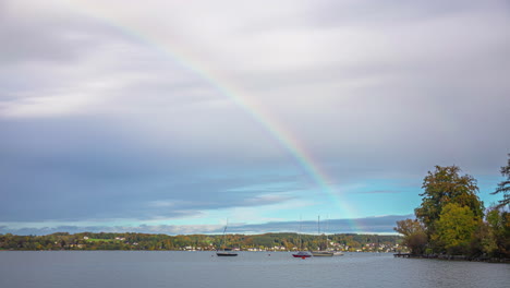 Rainbow-over-lake-Attersee-with-boats,-time-lapse-view