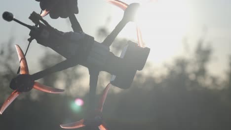 Drone-operator-holding-FPV-drone-in-his-hand-before-flying-in-the-morning-sky