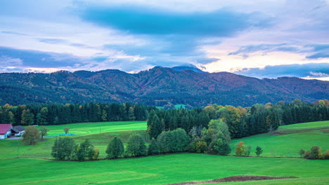 Autumn-countryside-view-with-green-meadows-and-mountain-in-background