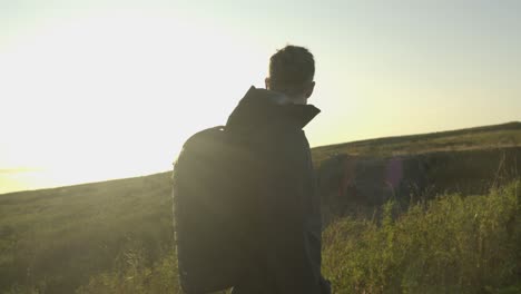 Slow-motion-shot-of-a-tourist-hiking-along-a-trail-at-sunset-in-Iceland