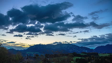 Himmelszeitraffer-Mit-Goldenen-Wolken-In-Einer-Bergigen-Landschaft-Bei-Sonnenuntergang