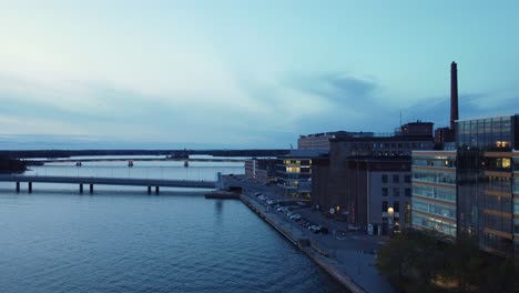 Helsinki-blue-hour-aerial-rises-over-Salmisaari-region-harbor-bridges