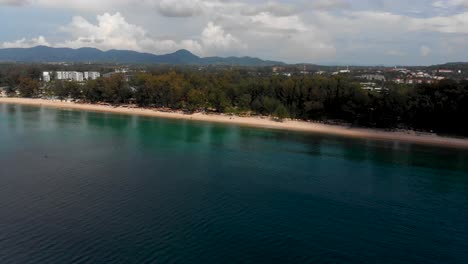 Toma-En-Cámara-Lenta-Con-Drones-De-La-Playa-Laguna-Ubicada-En-Bang-Tao-Beach,-Phuket,-En-La-Parte-Sur-De-Tailandia