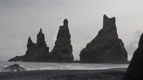 Reynisdrangar,-basalt-sea-stacks-located-on-the-coast-of-Iceland,-near-the-town-of-Vik-i-Myrdal